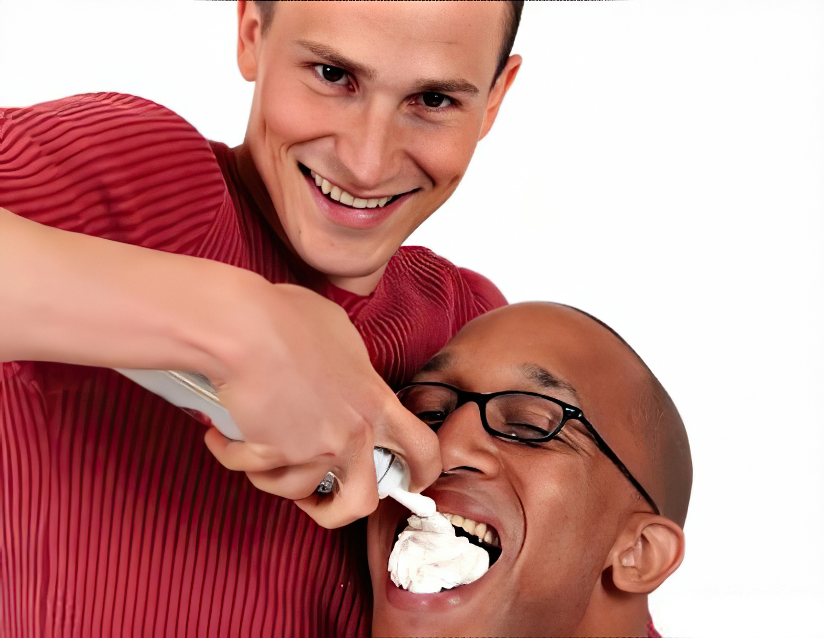 Guy Puts Whipped Cream In Another's Mouth - Stock Image - Smiling - chantilly
